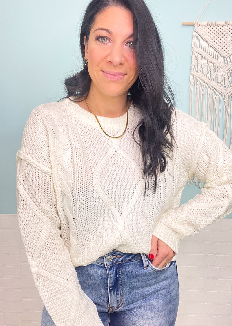 'Timeless' Ivory Cable Knit Notch Hem Sweater-A cable knit is a classic for all time! This cozy sweater has a shorter length with a notch hemline making it perfect to tuck in or wear untucked to show off the cute hem! Matches with all shades of denim and colored bottoms!-Cali Moon Boutique, Plainville Connecticut