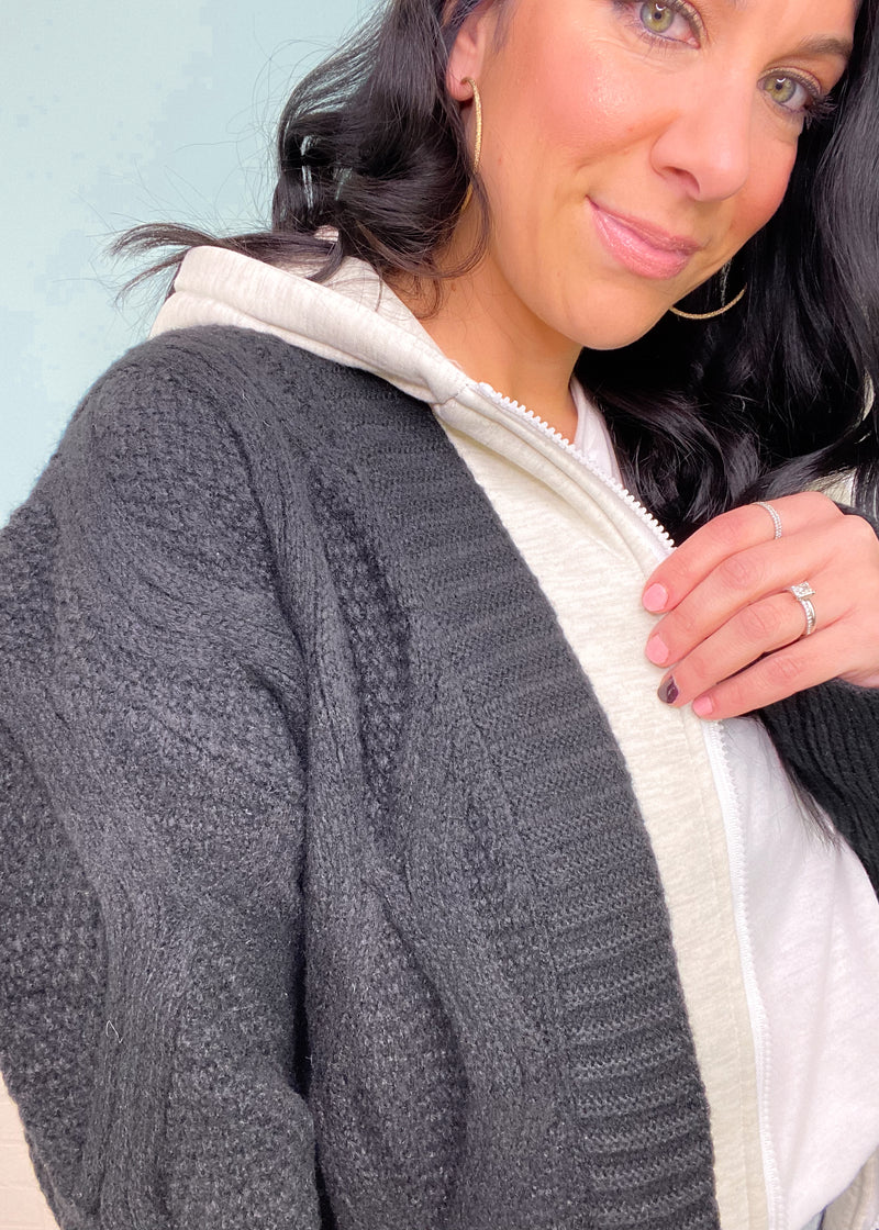 'Dream Team' Black Sweater Jacket with Attached Knit Hood-We can't think of a better cozy combination than this sweater jacket! The black diamond cable knit sweater paired with heather gray knit insert & hood is a dream! A classic color combo that you can wear with any bottoms! -Cali Moon Boutique, Plainville Connecticut