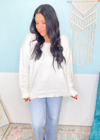 'Charmed' Ivory Cable Sleeve Soft Sweater-Classic cable knit design is perfectly placed in a tonal sleeve on this super soft and cozy sweater. The loose, rounded neckline allows you to wear it regular or slightly off shoulder.

Perfect for: Business casual, night out with boots/jeans, everyday with leggings/jeans with sneakers-Cali Moon Boutique, Plainville Connecticut